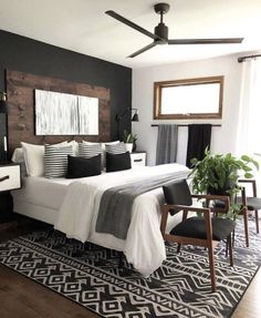 a bedroom with black and white decor, wood headboard