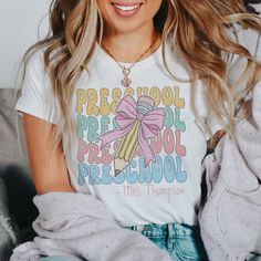 a woman sitting on a couch wearing a t - shirt that says preschool pre school