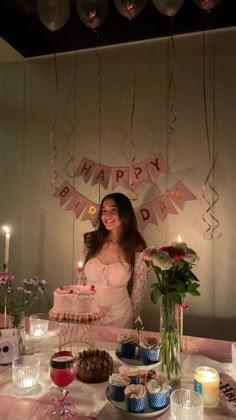 a woman standing in front of a birthday cake