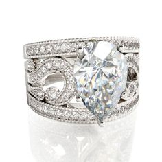 a white gold ring with a heart shaped diamond in the center, surrounded by diamonds