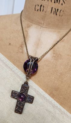 "I love this striking convertible amethyst cross necklace. The focal point of the necklace is a 3 1/2\" long pendant that is made of a large vintage brass and amethyst cabochon cross and a gorgeous large amethyst crystal set in vintage filigree. The beautiful vintage snake chain has been artfully extended so that the necklace can be worn long or short. The longest length is 27\" and the shortest is 16 1/2\". The last two pictures show that, if your neck is small, you might be able to wrap it aro Purple Amethyst Cross Jewelry, Purple Amethyst Cross Necklace, Vintage Adjustable Cross Pendant Necklace, Antique Cross Necklace For Jewelry Making, Antique Cross Necklaces For Jewelry Making, Adjustable Vintage Cross Pendant Necklace, Antique Cross Necklace For Gift, Spiritual Cross-shaped Gemstone Necklace, Spiritual Cross Shaped Gemstone Necklace