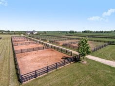 an aerial view of a horse farm with several stalls and fenced in areas around it