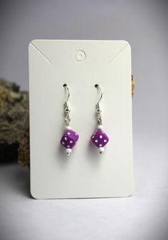 Lucky you! You found these adorable purple dice earrings! Great gift for gamers, gamblers, and fans of game night.  Small purple resin dice with white bead accents. Stainless steel ear hooks. ⭐These earrings are made to order and may contain a combination of new, vintage, and upcycled beads & and charms.⭐ Using upcycled/vintage materials is a part of BCE's commitment to sustainability. Upcycled beads and charms can be irregular in shape and color.  ⭐⭐ The hypoallergenic properties of upcycled co Purple Novelty Jewelry For Pierced Ears, Purple Dice, Lucky Earrings, Dice Earrings, Purple Resin, Resin Dice, Jewelry Statement, Earrings Unique, Gamer Gifts