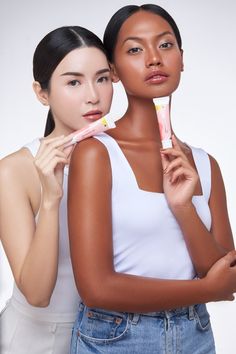 two beautiful young women standing next to each other with toothbrushes in their hands