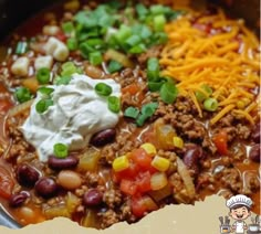 a bowl filled with chili, beans and sour cream