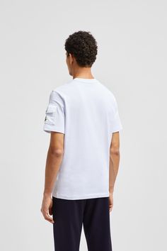 This cotton jersey t-shirt features an oversized logo print. A subtle reference to iconic outerwear styles, the crew neck features a pocket on the sleeve. White Short Sleeve Tops With Patch Pockets, Urban Cotton Tops With Patch Pockets, Cotton Tops With Patch Pockets For Streetwear, White Graphic Tee With Pockets, Urban Cotton Tops With Cargo Pockets, Sporty Crew Neck T-shirt With Pockets, White Crew Neck T-shirt With Pockets, Crew Neck Tops With Side Pockets For Streetwear, White Cotton T-shirt With Side Pockets