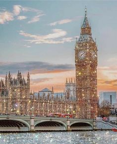 the big ben clock tower towering over the city of london at dusk with lights on