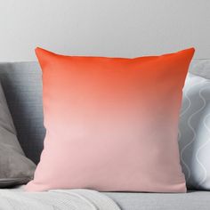 an orange and pink ombreed throw pillow on a couch