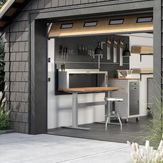 a garage with an open door and tools on the counter top in front of it