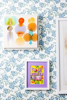 three framed pictures hang on the wall next to each other with flowers and blue leaves