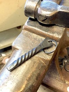 an old pair of scissors sitting on top of a piece of metal with holes in it