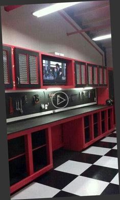 a black and white checkered floor in a garage with red cabinets on the wall