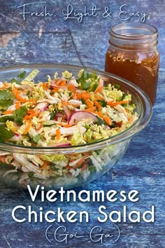 a glass bowl filled with chicken salad next to a jar of dressing