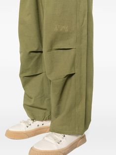 olive green organic cotton canvas naturally dyed elasticated waistband two side flap pockets rear flap pocket pleat detailing embroidered logo to the knee drawstring ankles drawstring fastening When buying this unisex item, keep in mind that it is graded in standard men's sizing. This item is made from at least 50% organic materials. We've partnered with Good On You — an independent agency that rates how brands perform in relation to their impact on the planet, people and animals, with a multi-criteria rating simplified to a five points scale. In order to be awarded our conscious label, larger brands need to score a minimum of four out of five ('Good'), while smaller brands must score at least three out of five ('It's a start'). This item comes from a brand rated five out of five ('Great') Military Style Cotton Bottoms With Elastic Waistband, Military Style Cotton Parachute Pants With Multiple Pockets, Cotton Parachute Pants With Multiple Pockets, Military Style Cotton Cargo Pants With Elastic Waistband, Military Cotton Cargo Pants With Elastic Waistband, Military Style Cotton Parachute Pants With Hip Pockets, Khaki Cotton Parachute Pants With Multiple Pockets, Military Style Baggy Cotton Parachute Pants, Khaki Cotton Cargo Parachute Pants