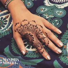 a woman's hand with henna tattoos on it