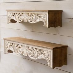 two white wooden shelves on the side of a wall, one with wood shelf brackets