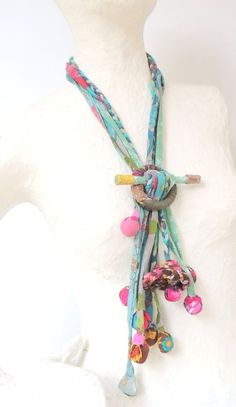 a white mannequin wearing a multicolored necklace on it's neck