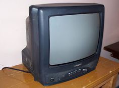 an old television sitting on top of a wooden table