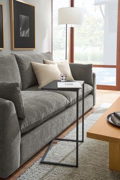 a living room with couches, table and pictures hanging on the wall above them