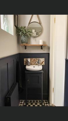 a bathroom with a sink, mirror and shelf above the sink is decorated in black and white checkered tile