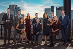 a group of people posing for a photo in front of a city skyline with skyscrapers