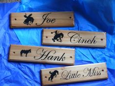 three wooden signs with the names of four different animals on them, one for each child's name