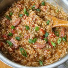 a pot filled with rice and meat on top of a wooden table