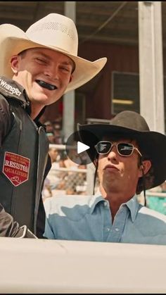 two men in cowboy hats and sunglasses sitting next to each other