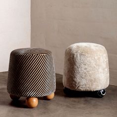 two small stools sitting next to each other on top of a cement flooring