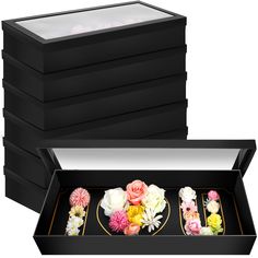 a black box filled with lots of different types of flowers on top of each other