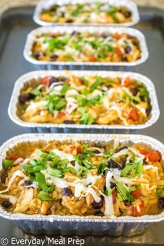 four pans filled with food sitting on top of a counter next to each other