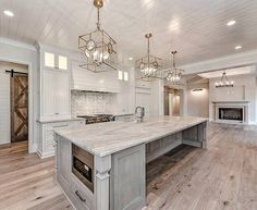 a large kitchen with an island in the middle and two ovens on each side