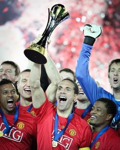 the manchester united players celebrate with the trophy