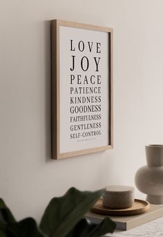 a wooden frame hanging on the wall above a table with a potted plant next to it