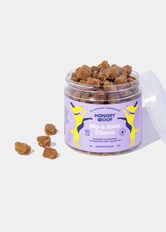 a jar filled with dog treats next to it's contents on a white surface