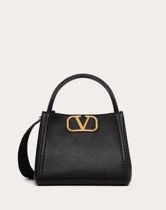 Valentino Garavani Alltime medium handbag in grainy calfskin with metallic VLogo Signature element. The bag can be worn on the shoulder/crossbody thanks to the shoulder straps or carried by hand thanks to the leather handles. - Antique brass-finish hardware - Magnetic closure - Adjustable and detachable ribbon shoulder strap - Adjustable and detachable leather shoulder strap - Protective feet - Interior: one zipped pocket - Leather shoulder strap drop length: 50 cm / 19.7 in. - Dimensions: W26xH Studded Sneakers, Oxford Boots, Medium Handbags, Valentino Rockstud, Ferragamo Belt, Fendi Belt, Prada Wallet, Chanel Belt, Dior Wallet