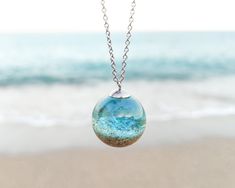 Can you imagine having a little piece of sea caressing your neck? 🌊🌊 Let me show you that little breath of nature in the form of this beach sand necklace, an ocean water necklace that is part of my Ocean theme jewelry. When you want to return to the sea, here you have this unique gift for the beach lover. When you long for the whisper of the sea, my blue resin necklace will transfer you there. When you need to know that the sea awaits you, this beach sand necklace will take you there. This daz Water Themed Accessories, Resin Ocean Jewelry, Water Themed Jewelry, Ocean Themed Accessories, Ocean Trinkets, Water Themed Outfits, Ocean Accessories, Water Necklace, Sand Jewelry