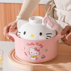 a hello kitty pot is being held by someone