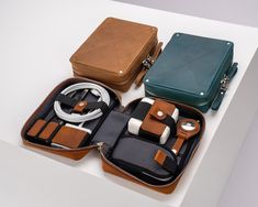 three pieces of luggage sitting on top of a white table next to an electronic device