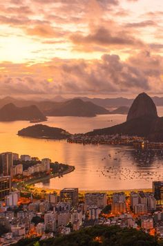 an aerial view of the city and water at sunset