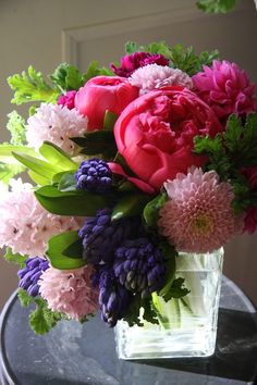 a vase filled with pink and purple flowers