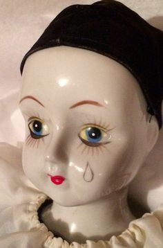 an old porcelain doll with blue eyes and red lips