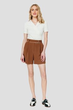 a woman wearing brown shorts and a white shirt