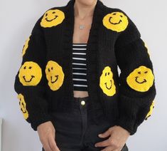 The cardigan is knitted with soft and thick yarns and is completely handmade. The cardigan is 50... 55 cm long and can be knitted to the desired length. The emoji motifs on it are fixed with 3D processing technique. The cardigan, which can be machine washed in a short program, does not fade. So why the affordable price? As HeyÇKnitting, I trust my designer cardigans and want all women in the world to wear these designs with pleasure COLOR: black. (Desired color can be knitted upon order.) MODEL: Black Chunky Knit Long Sleeve Cardigan, Black Chunky Knit Winter Cardigan, Black Chunky Knit Cardigan For Winter, Trendy Black Knit Sweater, Hand Knitted Black Sweater For Winter, Hand Knitted Black Sweater For Fall, Trendy Black Chunky Knit Outerwear, Black Knit Cardigan For Winter, Black Hand Knitted Sweater For Fall