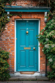 a blue door is in front of an orange brick building with vines and flowers around it