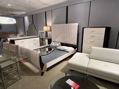 a living room filled with furniture next to a glass table and couch on top of a carpeted floor