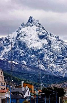 a large snow covered mountain towering over a city