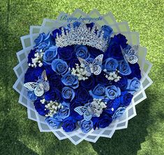 a bouquet of blue roses and butterfly brooches on top of a green field