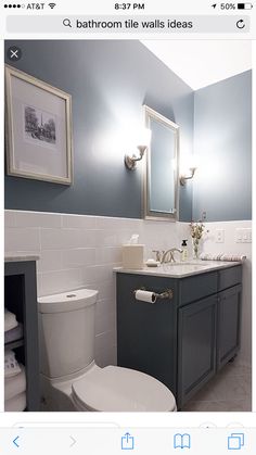 a white toilet sitting next to a sink in a bathroom under two framed pictures on the wall