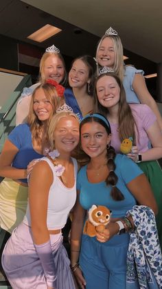 a group of young women standing next to each other in front of a stair case